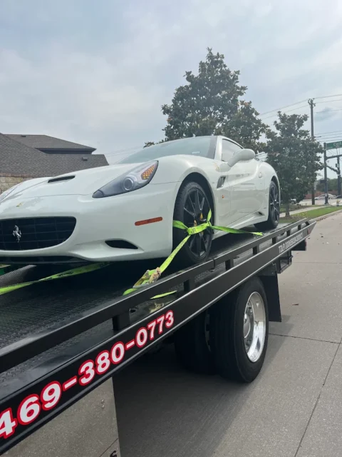 White Ferrari strapped down on a Towing Squad flatbed